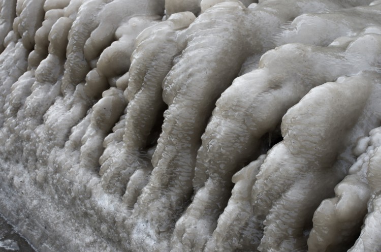 stalactite-like cascades of ice surrounded the edges of the snow pile