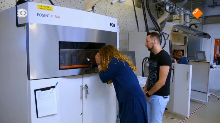 Rachel peeks at her dress inside the 3D printer 